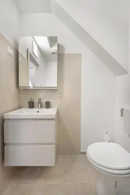 a white bathroom with a toilet and a sink at SMART APARTMENT LJUBLJANA in Spodnja Šiška