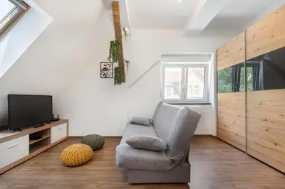 a living room with a chair and a television at SMART APARTMENT LJUBLJANA in Spodnja Šiška