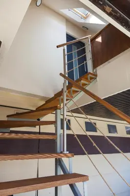 a staircase in a building with wood and metal railing at SMART APARTMENT LJUBLJANA in Spodnja Šiška