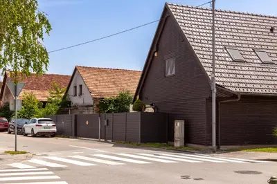 a black house with a fence next to a street at SMART APARTMENT LJUBLJANA in Spodnja Šiška