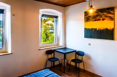 a room with two chairs and a table and a window at LAAS ART GALLERY in Stari Trg pri Ložu
