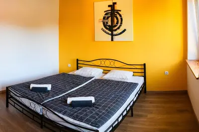 a bedroom with a bed with two pillows on it at LAAS ART GALLERY in Stari Trg pri Ložu