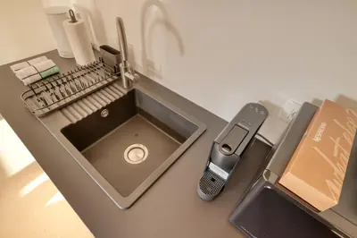 a kitchen counter with a sink and a cell phone at Dragon Residence in Ljubljana