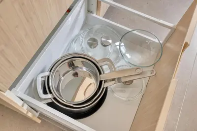 a drawer with a pot and glasses in it at Dragon Residence in Ljubljana
