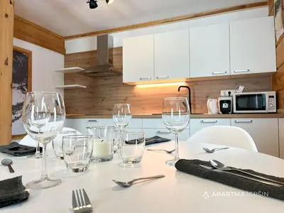 a table with wine glasses on it in a kitchen at Apartment Jeršin in Rateče