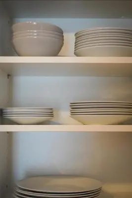 two white bowls and plates are sitting on shelves at Apartment Jeršin in Rateče