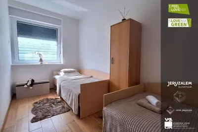 a small bedroom with two beds and a cabinet at POD OREHI - Hiša na podeželju - RAZPRŠENI HOTEL Jeruzalem Slovenija in Miklavž pri Ormožu