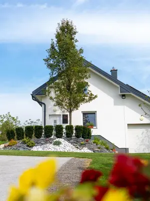 a house with a tree in the front yard at POD OREHI - Hiša na podeželju - RAZPRŠENI HOTEL Jeruzalem Slovenija in Miklavž pri Ormožu