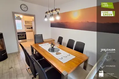 a dining room with a wooden table and chairs at POD OREHI - Hiša na podeželju - RAZPRŠENI HOTEL Jeruzalem Slovenija in Miklavž pri Ormožu