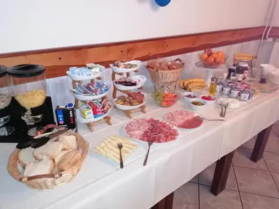 a buffet of food on a white table at Domačija Malnarjevi in Villa Slavina