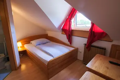 a small bedroom with a bed and a window at Domačija Malnarjevi in Villa Slavina