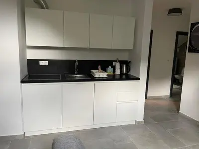 a kitchen with white cabinets and a sink at Apartma Med smrekami Golte in Mozirje