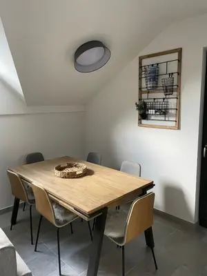 a dining room with a wooden table and chairs at Apartma Med smrekami Golte in Mozirje
