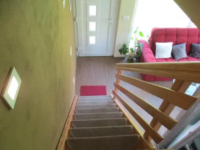 a staircase with a red couch in a room at Holiday Home Krn&Relax in Kobarid