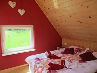 a bedroom with a bed with red walls and a window at Holiday Home Krn&Relax in Kobarid