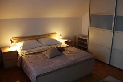 a bedroom with a large bed with two pillows at Apartments Koblar in Kranjska Gora