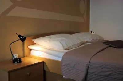 a bedroom with a bed and a lamp on a night stand at Apartments Koblar in Kranjska Gora