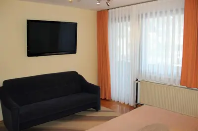 a living room with a couch and a flat screen tv at Apartments Koblar in Kranjska Gora