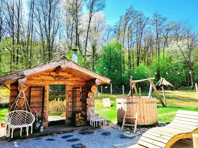 a log cabin with a swing and a playground at Koča na samem in Moravske Toplice