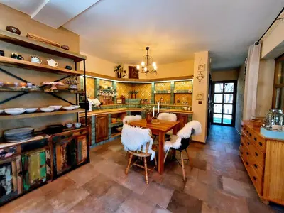 a large kitchen with a wooden table and chairs at Koča na samem in Moravske Toplice