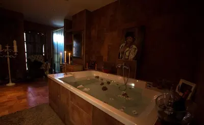 a large bathroom with a tub with a statue of a woman at Koča na samem in Moravske Toplice