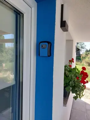 a blue door with a clock on the side of a house at Prenočišče ČERNOŠA Apartma Studio in Gradišče v Slovenskih Goricah