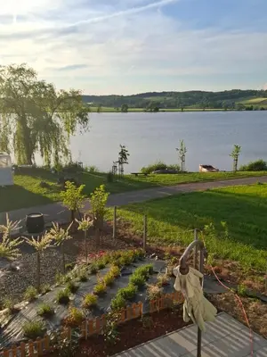 a garden with plants and a view of a lake at Prenočišče ČERNOŠA Apartma Studio in Gradišče v Slovenskih Goricah