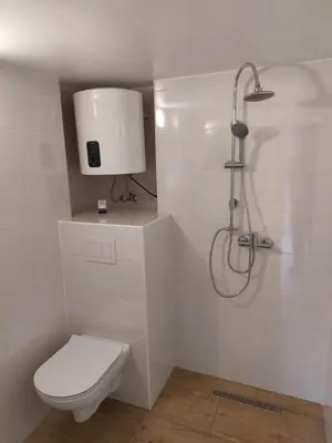 a white bathroom with a toilet and a shower at Prenočišče ČERNOŠA Apartma Studio in Gradišče v Slovenskih Goricah