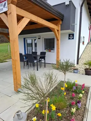 a covered patio with a table and chairs and flowers at Prenočišče ČERNOŠA Apartma Studio in Gradišče v Slovenskih Goricah