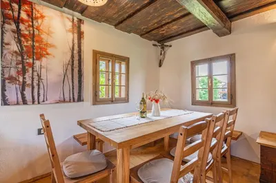a dining room with a wooden table and chairs at House Mimi in Metlika