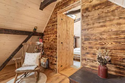 a room with a wooden wall and a wooden chair at House Mimi in Metlika