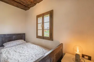 a small bedroom with a bed and a window at House Mimi in Metlika