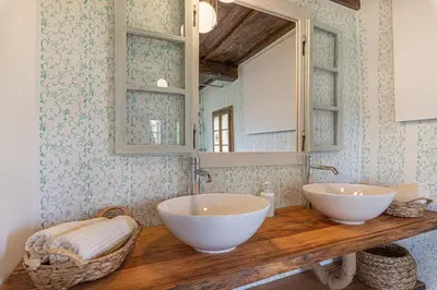 a bathroom with two white sinks and a mirror at House Mimi in Metlika