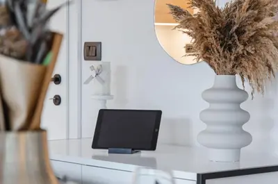 a desk with a computer and a vase with a lamp at Apartma Vila Center LUX in Slovenj Gradec