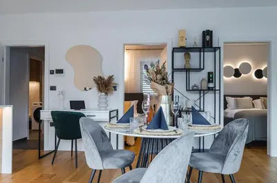 a living room with a table and chairs and a bed at Apartma Vila Center LUX in Slovenj Gradec