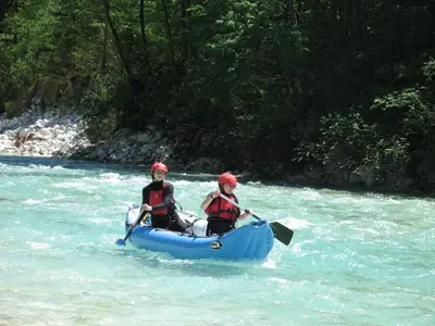 two people in a boat on a river at Apartment Mars in Bovec