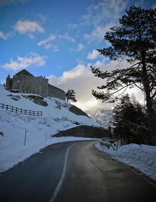 a road with a castle on top of a snow covered hill at Apartment Mars in Bovec