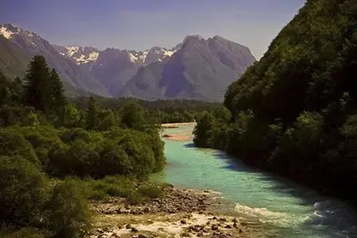 a river with green water and mountains in the background at Apartment Mars in Bovec