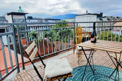 a balcony with a wooden table and a bench at Panoramic LOFT in the CityCenter in Maribor