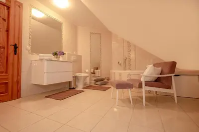 a bathroom with a sink and a table and chairs at Csárdás Salaš in Dobrovnik
