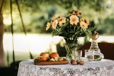 a table with a vase of flowers and fruit on it at Csárdás Salaš in Dobrovnik