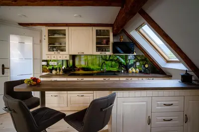 a kitchen with a sink and a counter with chairs at Panorama in Bohinj