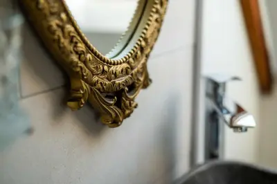 a gold mirror on the wall of a bathroom at Panorama in Bohinj