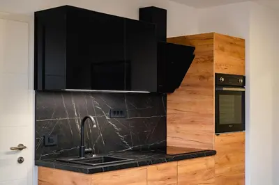 a kitchen with a black counter top and a sink at Apartments Luxury AD in Jesenice