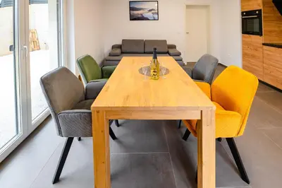 a dining room with a wooden table and chairs at Apartments Luxury AD in Jesenice