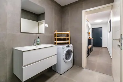 a bathroom with a washing machine and a sink at Apartments Luxury AD in Jesenice