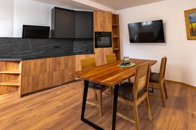 a dining room with a wooden table and a flat screen tv at Apartments Luxury AD in Jesenice