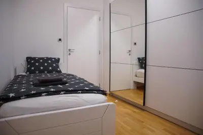 a bedroom with a bed and a large mirror at House Stars in Ljubljana