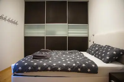 a bed with a black and white blanket and pillows at House Stars in Ljubljana