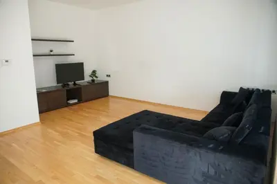 a living room with a black couch and a television at House Stars in Ljubljana